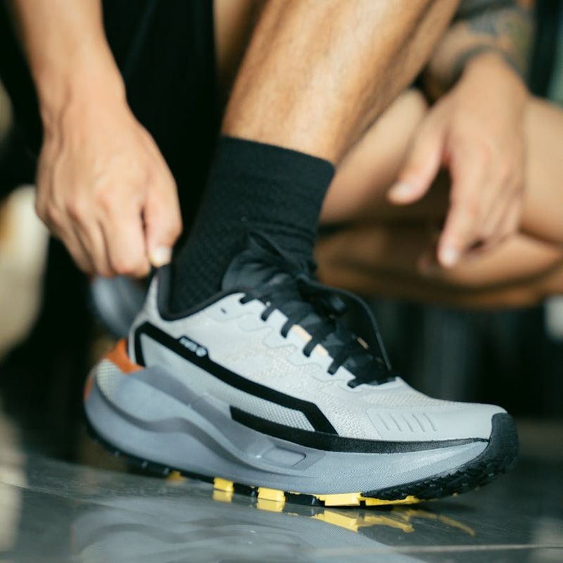 Close-up of athletic shoes on a dark floor.